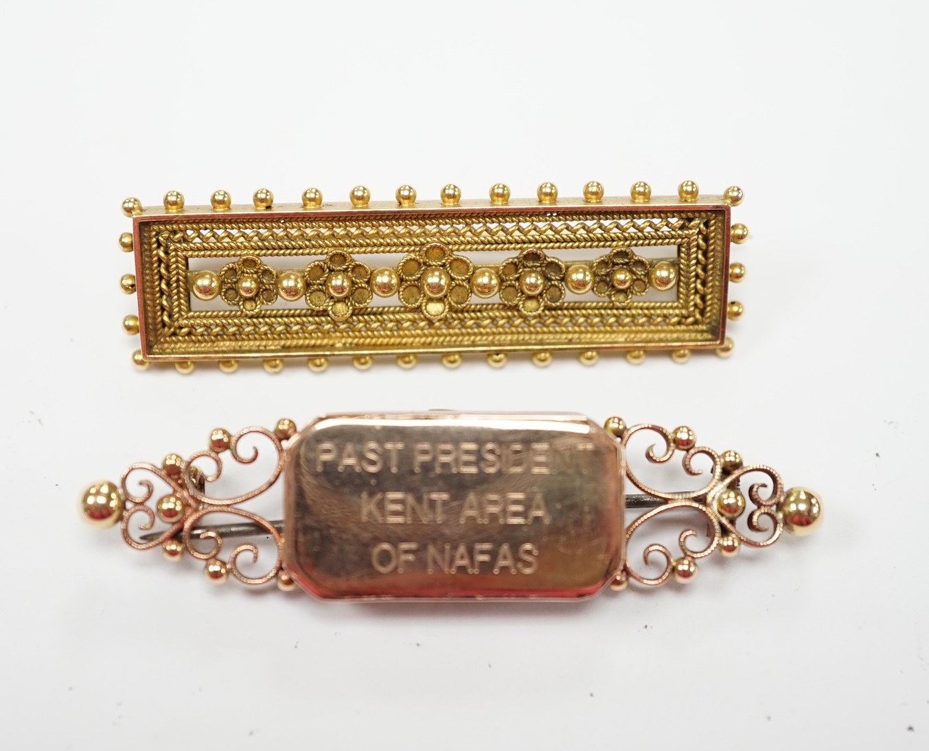 A late Victorian yellow metal cannetille work brooch, 45mm, 6.4 grams, together with a 15ct brooch, with later inscription, gross 6.2 grams. Fair condition.